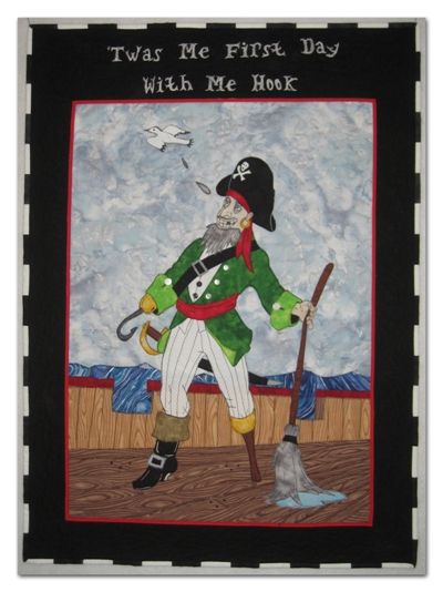 The inspiration drawing was by my husband, Michael Ellis. The materials are commercial cottons. The wording is done with thread painting and the pirate is raw-edge fusible appliqu.